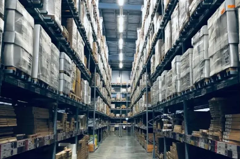 Raflar boyunca kolilerle dolu büyük bir depo koridoru